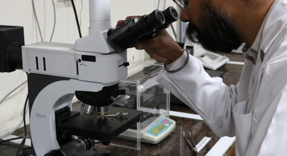 Researcher using a modern microscope to examine a specimen in a laboratory setting